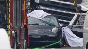 The black Porsche under the semi-trailer after the crash.