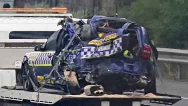 One police vehicle is towed from the scene of the crash.