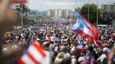 Demonstrators march on a highway blocking traffic during a protest in San Juan.