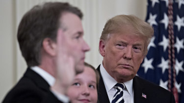 Donald Trump listens as Brett Kavanaugh takes the oath to become a Supreme Court judge.