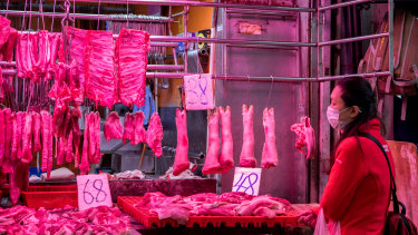 A woman buys meat in a market in Hong Kong.