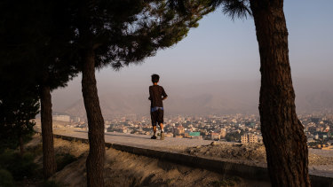 A boy runs along a wall at the top of Bibi Mahru Hill in Kabul, Afghanistan.