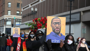 Demonstrators carry a symbolic coffin and images of George Floyd during an ‘I Can’t Breathe’ Silent March For Justice in Minneapolis, Minnesota, ahead of the trial.