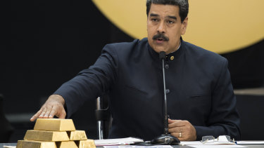 Venezuelan President Nicolas Maduro touches gold bars at a press conference  last year.