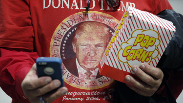 A Trump supporter with a box of popcorn attends a rally with US President Trump in Lexington, Kentucky.