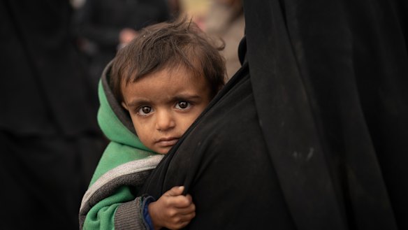 A woman holds her son as they wait to be screened by US-backed Syrian Democratic Forces (SDF) after being evacuated out of the last territory held by Islamic State militants, in the desert outside Baghouz, Syria, last week.