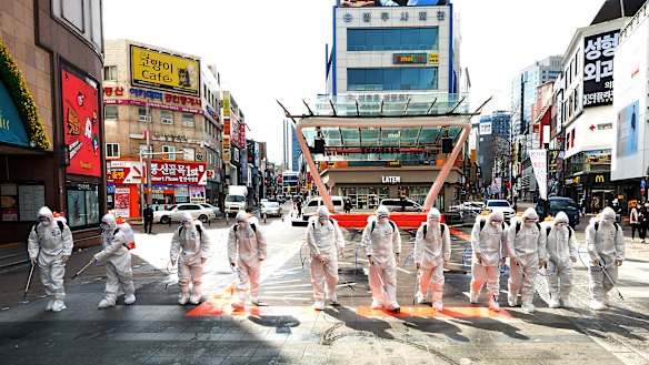 South Korean army soldiers wearing protective suits spray disinfectant to prevent the spread of the COVID-19 in Daegu.