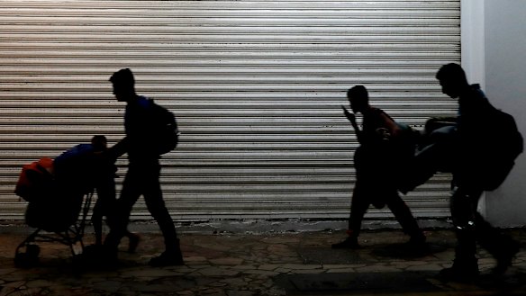 Families camped in a park leave in the middle of the night as they are pushed out by Mexican immigration authorities who cleared the park of Haitian and African migrants, in Tapachula, Mexico, last month.
