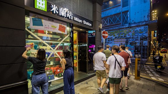 Workers fix tape to window panes at Milan station during preparations ahead of Super Typhoon Mangkhut's arrival at Central Hong Kong on Saturday.