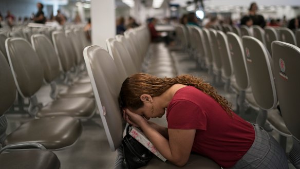 An evangelical kneels in prayer as she waits for pastor Silas Malafaia to speak at the Assembly of God Victory in Christ Church, in Rio de Janeiro.