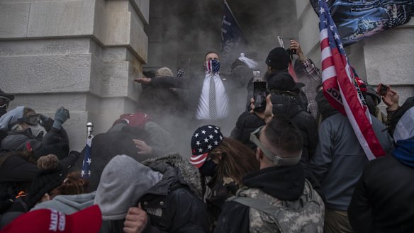 Demonstrators attempt to breach the US Capitol after they earlier stormed the building .