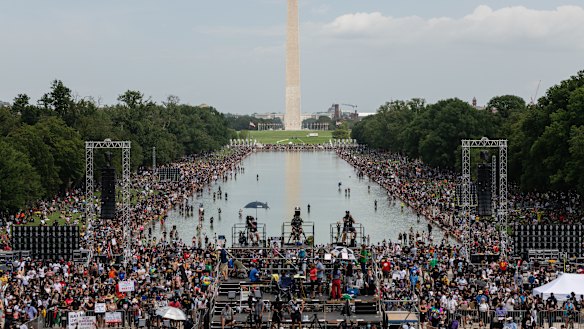 Demonstrators wearing protective masks gather during the 'Get Your Knee Off Our Necks' march on Washington.
