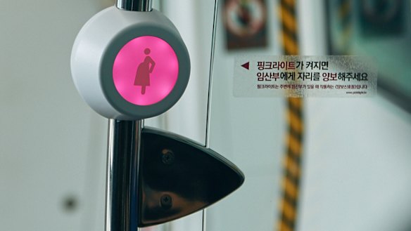 A sensor next to special priority seats, blinks with pink light, signals that a pregnant passenger is approaching or standing nearby..