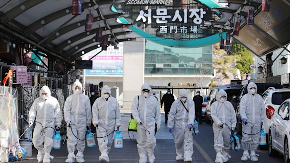 Workers spray disinfectant as a precaution against the COVID-19 at a local market in Daegu in South Korea.