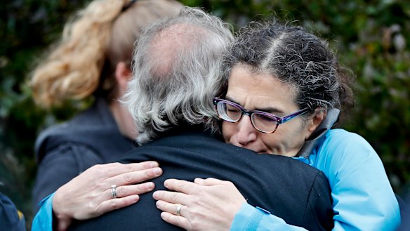 People embrace along the street in the Squirrel Hill district of Pittsburgh where a shooter opened fire during services at the Tree of Life Synagogue.