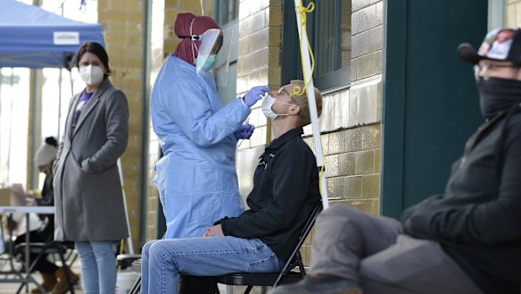 A medical staff member performs a Covid-19 test outside the Family Healthcare building in downtown Fargo, North Dakota.