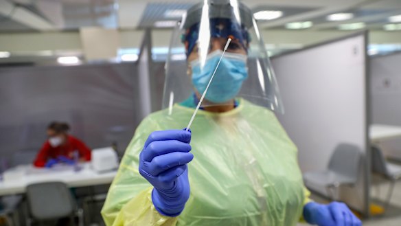 A healthcare worker holds a swab sample at the COVID-19 rapid test facility at Fiumicino Airport in Rome.