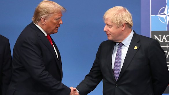 Boris Johnson shakes hands with US President Donald Trump onstage during the annual NATO heads of government summit.