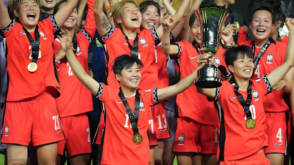 Ji So-Yun (left) lifts the EAFF E-1 Women’s Football Championship trophy.