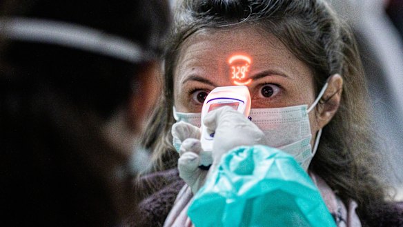 A woman is temperature tested at an airport in Hungary, which is battling a major second wave of coronavirus. 