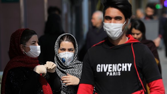 Pedestrians wear masks to help guard against the Coronavirus, in downtown Tehran, Iran.