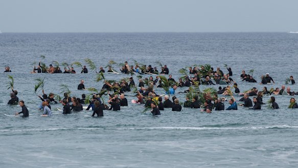 Surfers pay tribute to a beloved local, Mercury Psillakis, on Saturday.