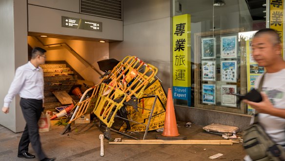 Barriers and other street furniture used by demonstrators sit in a pile at the bottom of a pedestrian overpass.
