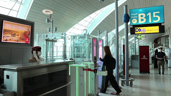A woman enters the face and iris-recognition gate to board a plane at Dubai Airport, in the United Arab Emirates. 
