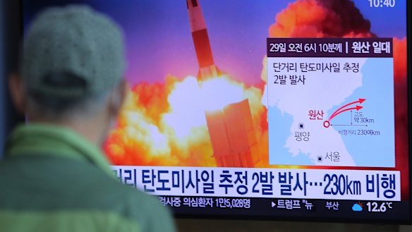 A man watches a TV screen in Seoul showing a file image of North Korea's missile launch.