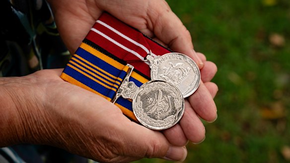 Cathy Griffin holds her Australian Army service medals. She has joined the chorus of objections to the sale of Victoria Barracks. 
