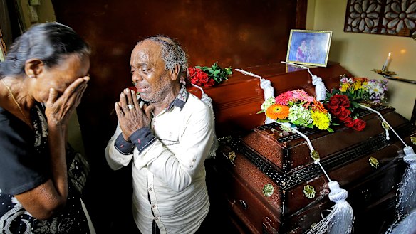 A Sri Lankan family mourns next to the coffins of their three family members, all victims of Easter Sunday bombings. 