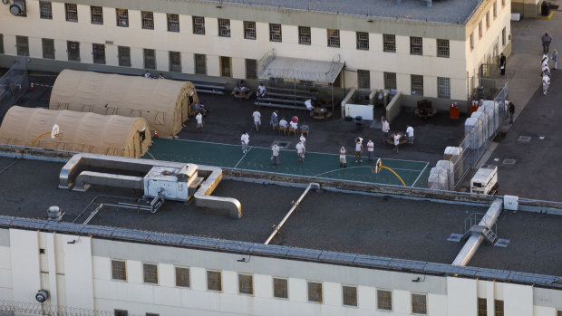 Inmates gather outside of tents at the Federal Correctional Institute Terminal Island prison in this aerial photograph taken above Los Angeles, California.
