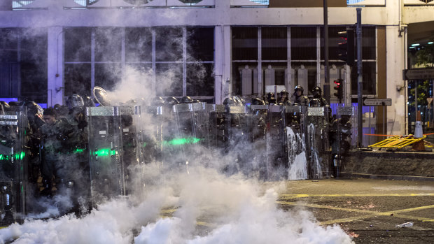 Riot police are shrouded in a cloud of tear gas on Connaught Road West during a protest in the Sheung Wan area of Hong Kong.