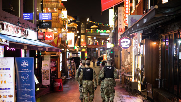 US Army military police patrol the street at night in the Itaewon area of Seoul, South Korea.