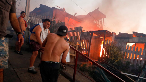 People help fight the bushfire with buckets after it reached buildings in Valparaiso, Chile, on Christmas Eve.