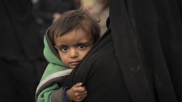 A woman holds her son as they wait to be screened by US-backed Syrian Democratic Forces (SDF) after being evacuated out of the last territory held by Islamic State militants, in the desert outside Baghouz, Syria, last week.