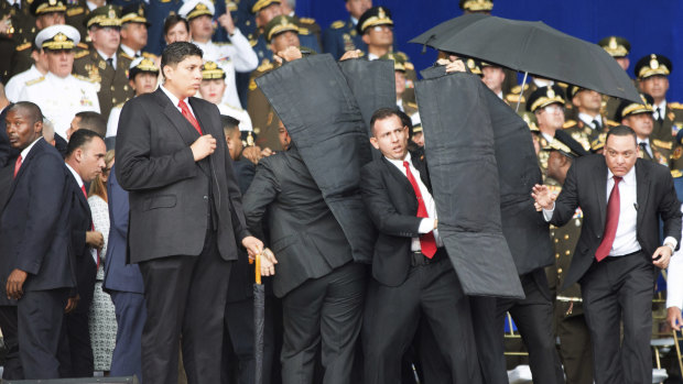 Security personnel surround Nicolas Maduro during an incident as he was giving a speech in Caracas.