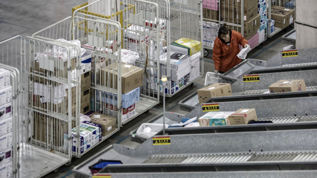 An employee handles a basket at a sorting facility inside JD.com's logistics base in Shanghai, China.