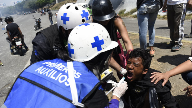 Medical personnel give first aid to a protester during a military uprising in Caracas on Tuesday.