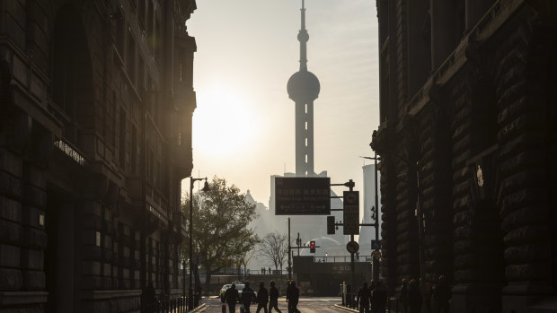Rising or falling: Workers cross a road near the Bund in Shanghai, China.
