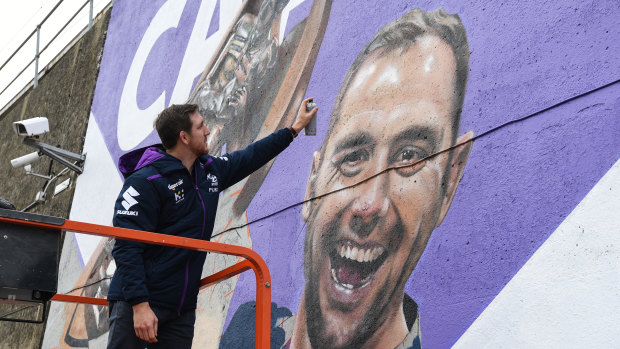 He's a Melbourne institution: Ryan Hoffman adds a few extra touches to the Cam400 mural at Richmond train station.