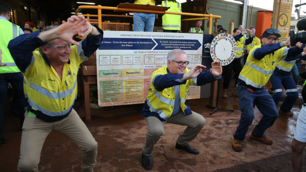 Prime Minister Scott Morrison joins Fortescue Metals Group’s CEO Andrew Forrest in morning stretches during a tour of the Christmas Creek mining operations, before visiting Kalbarri. 