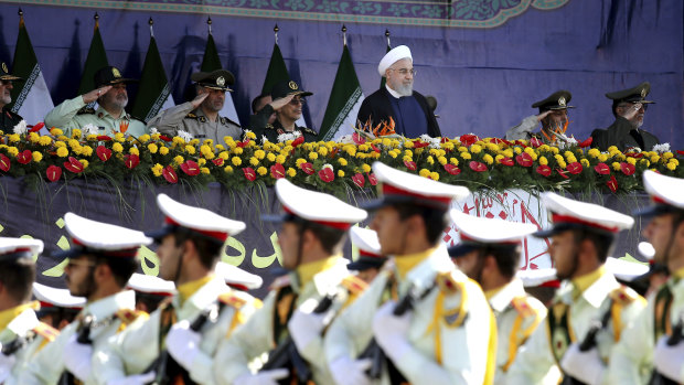 Iran's President Hassan Rouhani reviews army troops marching during the 38th anniversary of Iraq's 1980 invasion of Iran.