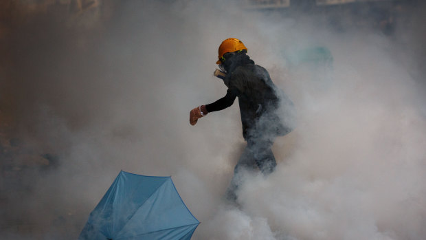 A protester walks in a cloud of tear gas during a protest against a proposed extradition law in Hong Kong.