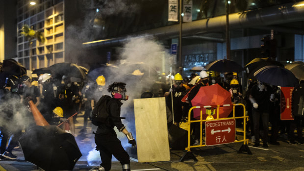 Demonstrators are shrouded in a cloud of tear gas outside the North Point Police Station in Hong Kong on Monday.