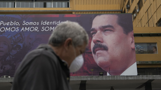 A pedestrian passes a billboard featuring an image of Venezuelan President Nicolas Maduro in Caracas.