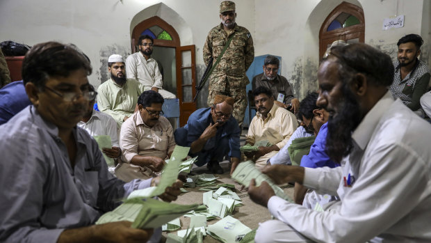 Polling agents count votes after polls closed at a polling station in Lahore.