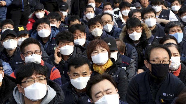 Workers wearing masks to protect themselves from air pollution attend a rally against the government's labour policy in Seoul last week.