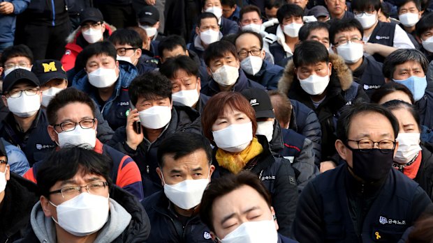 Workers wearing masks to protect themselves from air pollution attend a rally against the government's labour policy in Seoul last week.