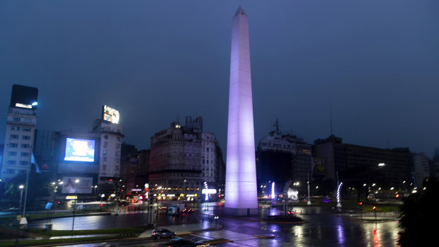 Cars drive past the illuminated Obelisk monument in Buenos Aires, Argentina, after power was restored.